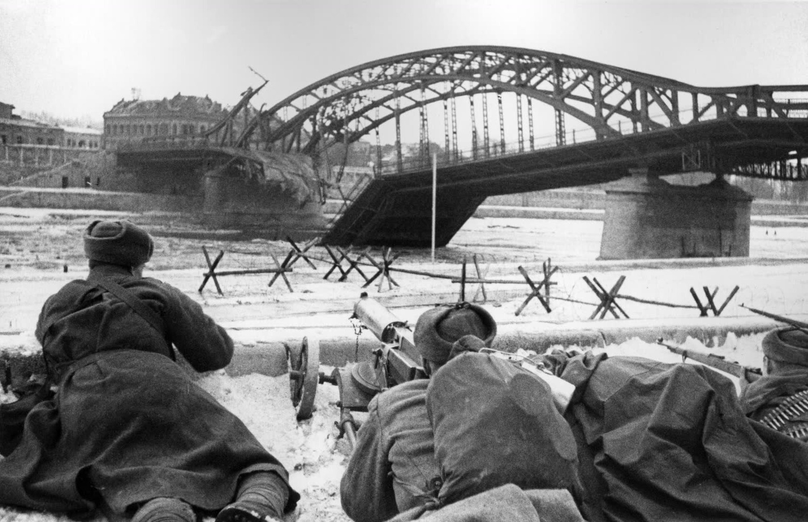 Советские бойцы с пулеметом «Максим» ведут огонь у разрушенного моста через реку Висла в боях за освобождение Кракова. Фотография Макса Альперта, январь-февраль 1945-го.